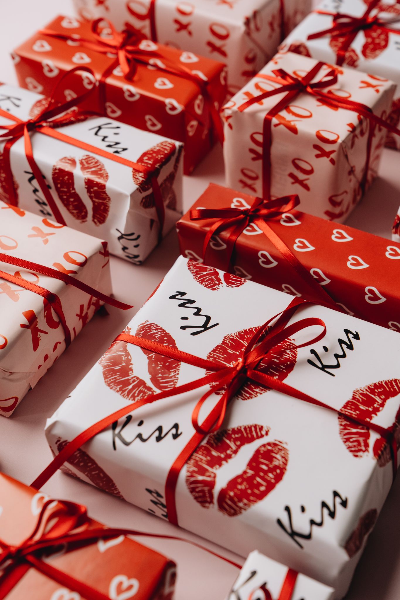 Valentine's Day gifts beautifully wrapped in themed paper with red ribbons, perfect for a romantic celebration.